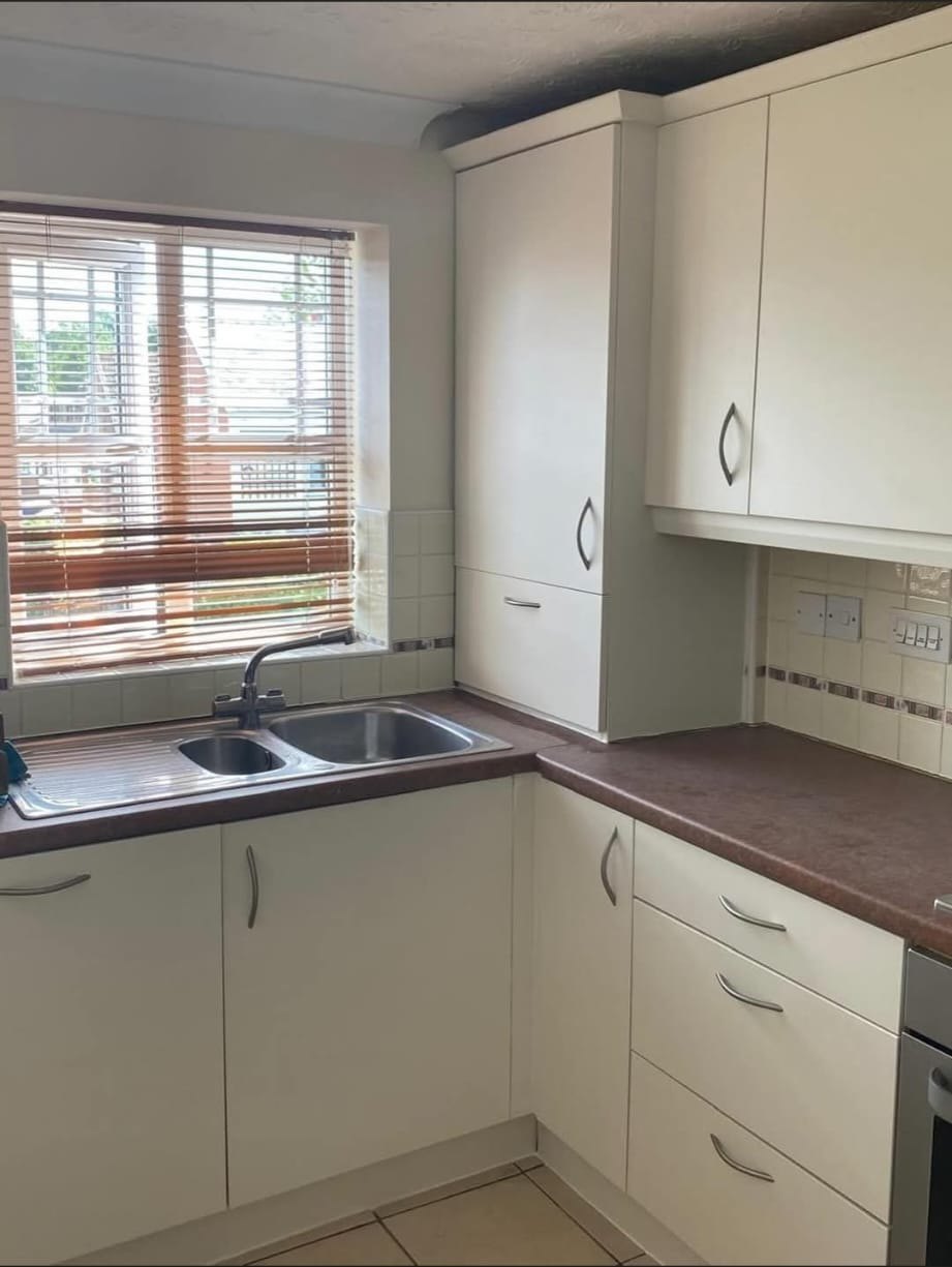 Cream wrapped kitchen units around the sink and window after vinyl wrap