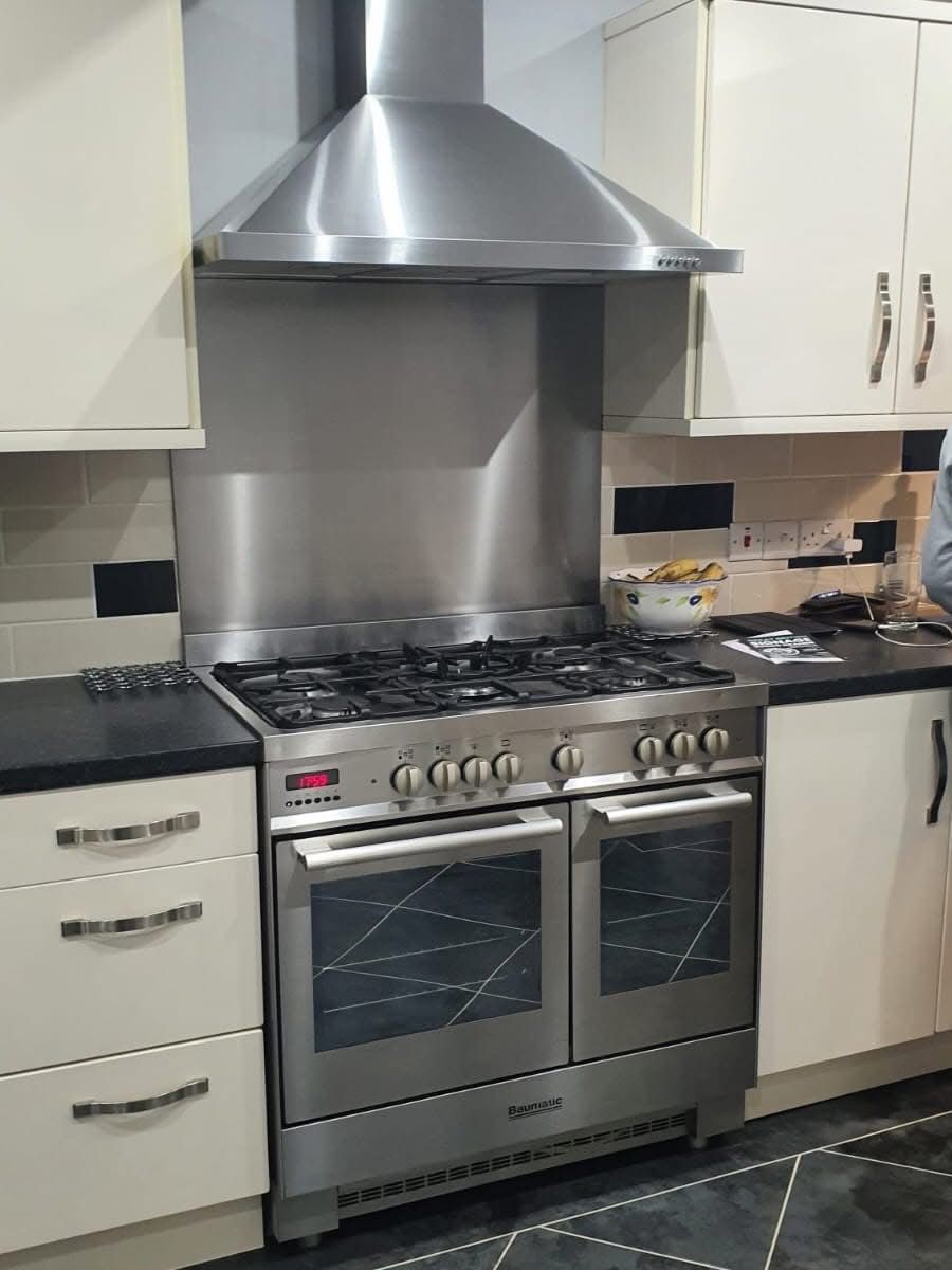 White kitchen cabinets with black worktop before vinyl wrap